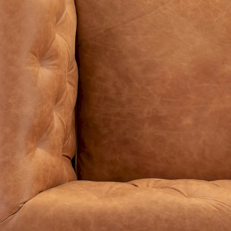 Fauteuil de salon capitonné en cuir italien avec pieds en bois massif et coussin en plumes