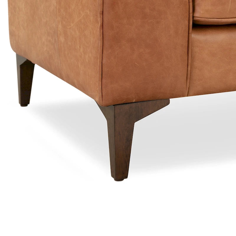 Fauteuil de salon capitonné en cuir italien avec pieds en bois massif et coussin en plumes