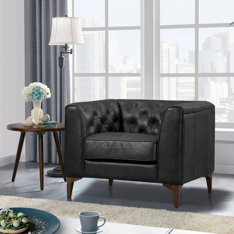 Fauteuil de salon capitonné en cuir italien avec pieds en bois massif et coussin en plumes