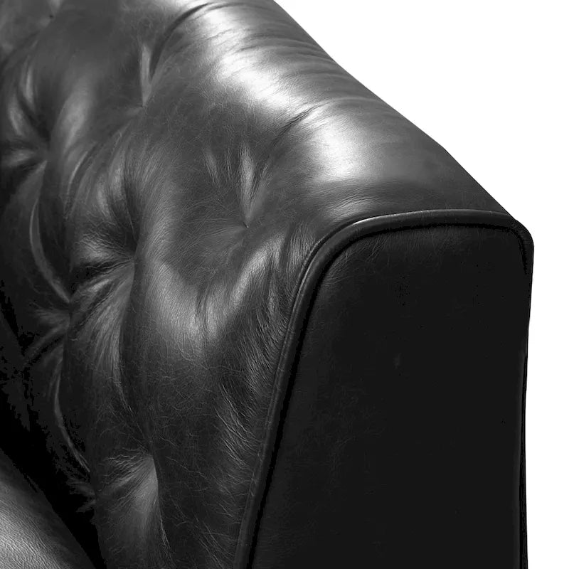 Fauteuil de salon capitonné en cuir italien avec pieds en bois massif et coussin en plumes
